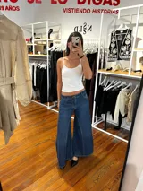 Jeans oxford de tiro medio-alto, confeccionados en 100% algodón. Presentan un diseño de perneras amplias con cortes verticales combinados en tonos de denim y costuras marcadas. Cuentan con bolsillos traseros, trabillas para cinturón y etiqueta de cuero en la parte posterior de la cintura.