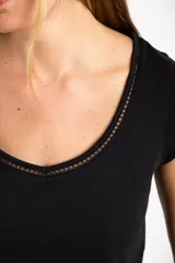 Remera blanca de algodón peinado, manga corta y escote en V con terminación de encaje calado.