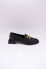 Mocasines de cuero en tono bronce metalizado, con detalle de aplique metálico dorado en el empeine y taco cuadrado bajo de madera.