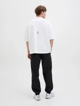 Buzo blanco de manga corta con corte holgado y cuello redondo. Estampa en la espalda con impresión de goma suave al tacto. Confeccionado en tejido de rizo sin cepillar, con superficie lisa y bucles en el interior.