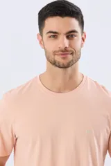 Remera lisa de manga corta y cuello redondo, color gris oscuro, de calce cómodo con pequeño logo bordado en el pecho.