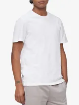 Remera blanca de algodón con cuello redondo y mangas cortas. Presenta un pequeño monograma bordado en el pecho.