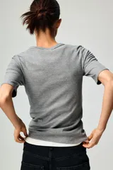 Remera de manga corta en punto acanalado, de modelo entallado con cuello redondo ribeteado.