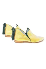 Botín de piel tornasolada con acabado brillante en tono amarillo lima y reflejos verdes. Presenta un diseño de dos piezas con bordes troquelados, aberturas laterales, ajuste con elásticos y un borlón decorativo de ante verde en la parte trasera. Incluye cuña interna y suela de cuero.