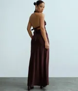 Pollera recta modelo new midi, confeccionada en satén negro sin estampado y con cintura elástica.