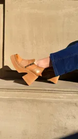 Zapatos de tacón alto y plataforma color camel, con inserción de cuero con textura en el empeine y doble cierre lateral decorativo.
