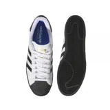 Championes adidas modelo Superstar ADV, de diseño clásico con exterior de cuero blanco, las icónicas tres tiras laterales en negro, puntera de goma negra y suela plana también en color negro.