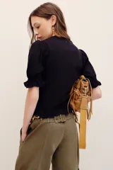 Camisa negra de punto con mangas cortas abullonadas y puños con volados.