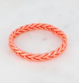 Pulsera rígida de color verde metálico con diseño trenzado.