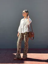 Cartera tipo bandolera de cuero color tostado, con solapa frontal, cierre principal y herrajes metálicos. Incluye dos correas desmontables, una corta para llevar al hombro y una larga ajustable para usar cruzada.