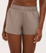Bermuda deportiva Get Over modelo runner color beige, con cintura elástica, bajo redondeado y aberturas laterales. Cuenta con un pequeño bolsillo funcional trasero.