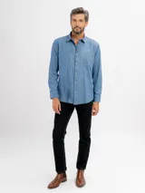 Camisa de jean de manga larga con cuello clásico, cierre frontal con botones y un bolsillo en el pecho.