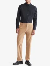 Camisa negra de manga larga con cuello clásico y cierre con botones. Tiene un pequeño logo de Calvin Klein bordado en el pecho.