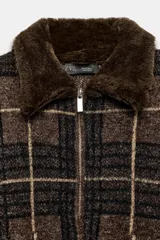 Chaleco de punto con diseño de cuadros, cuello solapa de pelo sintético a contraste y cierre frontal con cremallera metálica.