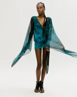 Minivestido azul con estampado abstracto, escote en V con detalle metálico y mangas largas acampanadas de tul.