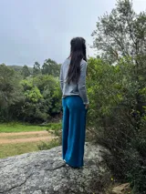 Pantalón palazzo de tiro alto, color azul, confeccionado en plush de algodón con faja ancha en la cintura y bolsillos laterales amplios.