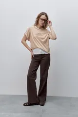 Remera blanca de silueta amplia y calce relajado, confeccionada en tela suave y liviana, con cuello redondo, mangas cortas con vuelta y hombros caídos. Cuenta con un delicado bordado frontal en color azul con la inscripción "LE SOLEIL TOUTE L'ANNÉE sur la Côte d'Azur".