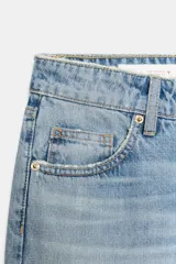 Jeans de tiro bajo con corte wide leg y largo cropped. Presenta diseño de cinco bolsillos, trabillas para cinturón y cierre frontal con cremallera y botón metálico.