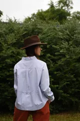 Sombrero marrón de ala ancha confeccionado en paño de lana afieltrada a mano, con cinta decorativa del mismo material alrededor de la copa.