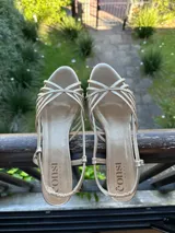 Sandalias chatas doradas de la marca Consi, con múltiples tiras finas cruzadas en la parte delantera y tira elástica en el talón.