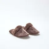 Pantuflas tipo mule color marrón, confeccionadas en material aterciopelado con borde de pelo sintético en la parte superior y suela plana.