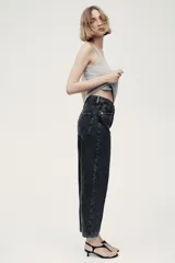 Jean tobillero estilo barrel de cinco bolsillos en denim de algodón rígido, con diseño curvo en las piernas y tiro alto.