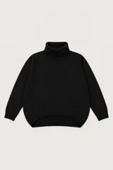 Polera de punto color negro con cuello alto, diseño de corte holgado y ruedo asimétrico con detalle de costura frontal.