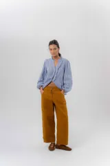 Pantalón de gabardina de algodón con calce barrel, tiro medio-bajo, cartera con botones semiocultos y recortes en las piernas. Cuenta con ruedo ajustable con botones para lograr efecto bombé.