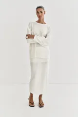 Jersey de punto fino con diseño oversize, cuello redondo y manga larga.