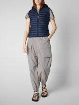 Chaleco acolchado ligero color gris topo, con capucha y cierre frontal. Confeccionado con relleno sintético Plumtech.