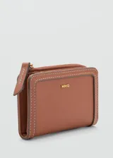 Billetera pequeña de cuero sintético con efecto saffiano color tostado, de diseño compacto con seis ranuras para tarjetas, bolsillo lateral con cierre de cremallera y cierre de solapa con botón a presión. Incluye detalle de costuras pespuntadas y el logo de la marca estampado en color dorado en el frente.