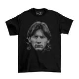 Remera negra de algodón con estampado frontal en escala de grises que representa el rostro de Lionel Messi en sus inicios.