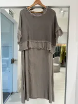 Vestido midi color gris visón, de corte recto y holgado. Cuenta con una capa superior superpuesta de tejido de punto abierto estilo red, con mangas cortas y terminaciones deshilachadas.
