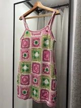 Vestido corto tejido al crochet con cuadrados de colores rosa, verde y blanco.