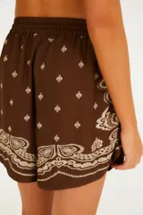 Short de viscosa color marrón con estampado paisley en tonos beige, corte holgado, tiro medio y cintura elástica con cordón ajustable.