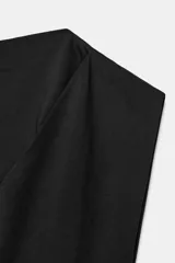 Top de algodón color beige con cuello recto, mangas asimétricas y detalle de tejido drapeado en el frente.