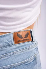 Pantalón de jean estilo wide leg color azul claro, con diseño de tiro alto, corte holgado y roturas desgastadas en ambas rodillas.