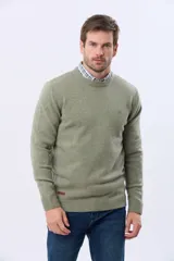 Buzo tejido de lana con escote redondo a la base y mangas largas. Presenta puños y ruedo acanalados, con un pequeño logo bordado en el pecho.