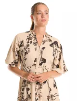 Vestido maxi de crepe color beige con estampado floral en tonos marrones y negros. Presenta cuello a la base, escote en V, abertura central con botones y cintura con lazo de ajuste y hebilla.