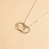 Collar con dije compuesto por tres aros entrelazados de plata 925, con cadena de eslabones tipo veneciana.