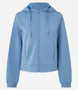 Campera deportiva de corte regular confeccionada en modal, con cierre frontal por cremallera, capucha con cordón ajustable, mangas largas con puños elásticos y bolsillos laterales.