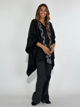 Ruana marrón con detalle de trenza frontal y terminación con flecos.