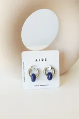 Aros de argolla en acero quirúrgico con dije de piedra natural en tono azul.