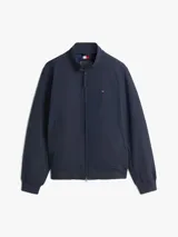 Campera tipo Harrington de Tommy Hilfiger en color azul marino, de corte amplio. Cuenta con cuello alto, cierre frontal de cremallera, bolsillos de ojal en la cintura y el pecho con el logo bordado.