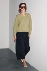 Jersey de punto confeccionado en lana 100%, con escote en pico y manga larga de corte holgado.