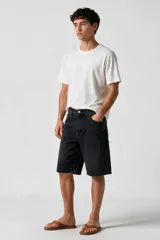 Bermuda de jean de corte ancho y tiro medio, color negro con efecto lavado.
