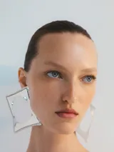 Aros grandes plateados con forma cuadrada y borde con relieve de pequeñas esferas. Cierre de broche.