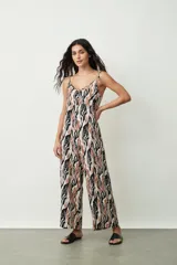 Monoprenda (jumpsuit) de mujer con estampado abstracto en tonos negro, marrón y blanco. Presenta escote en V, tirantes finos ajustables y pierna ancha tipo palazzo.