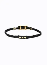 Cinturón negro trenzado de cuero, con hebilla rectangular dorada con piedra negra.