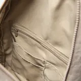 Mochila urbana de tela arrugada color beige, con múltiples compartimentos con cierre, bolsillos laterales y logo circular de la marca en el frente.